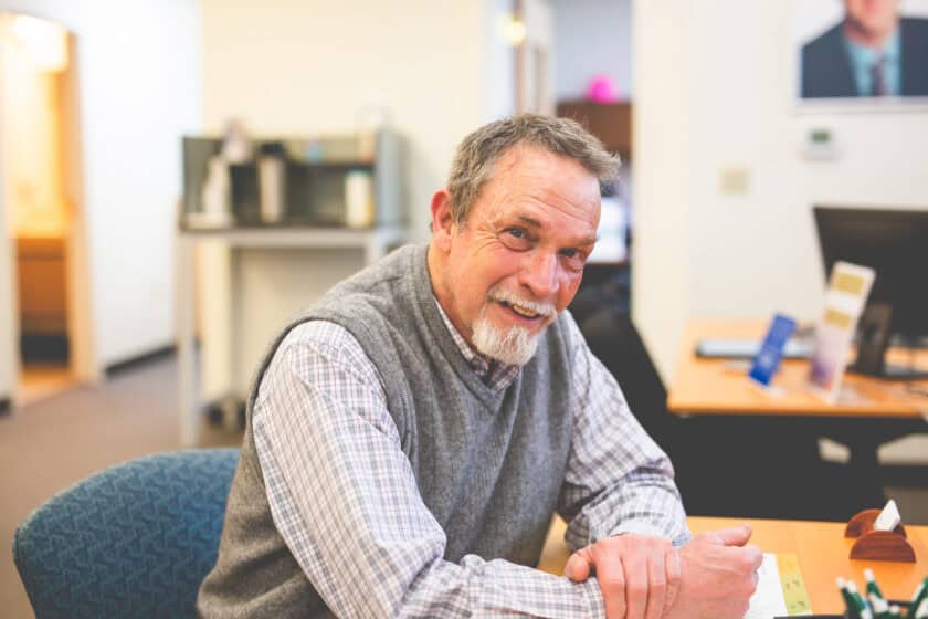 A member sitting at a desk and smiling