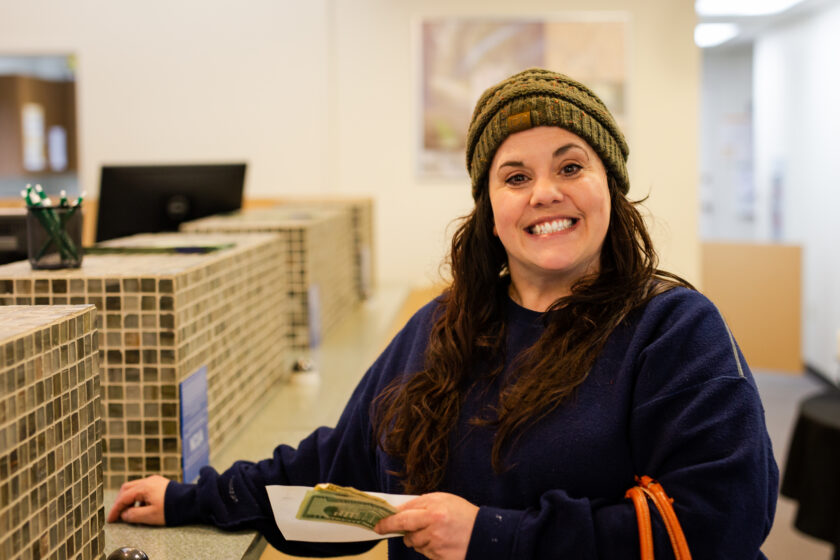 A woman at the teller line smiling at the camera