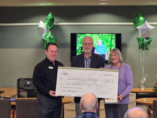 Jim Morrell, CEO, and John Bolender, Board Chair, present a check to Sue Barnard, retiring board member