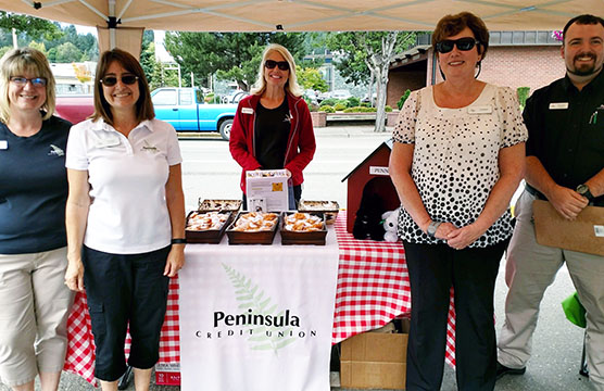 Peninsula Employees under a tent at a community event.