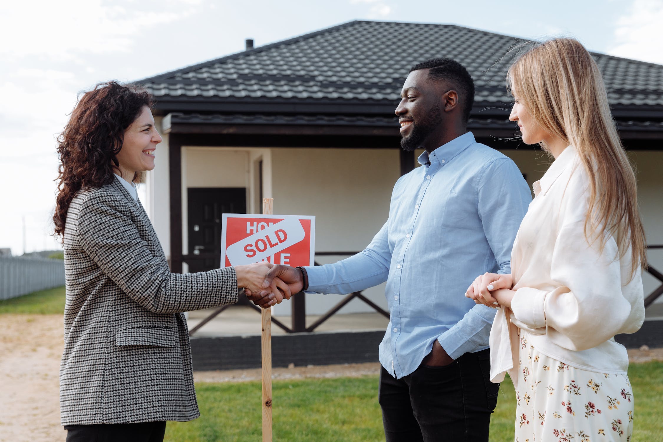 A real estate agent shaking hands with new homeowners