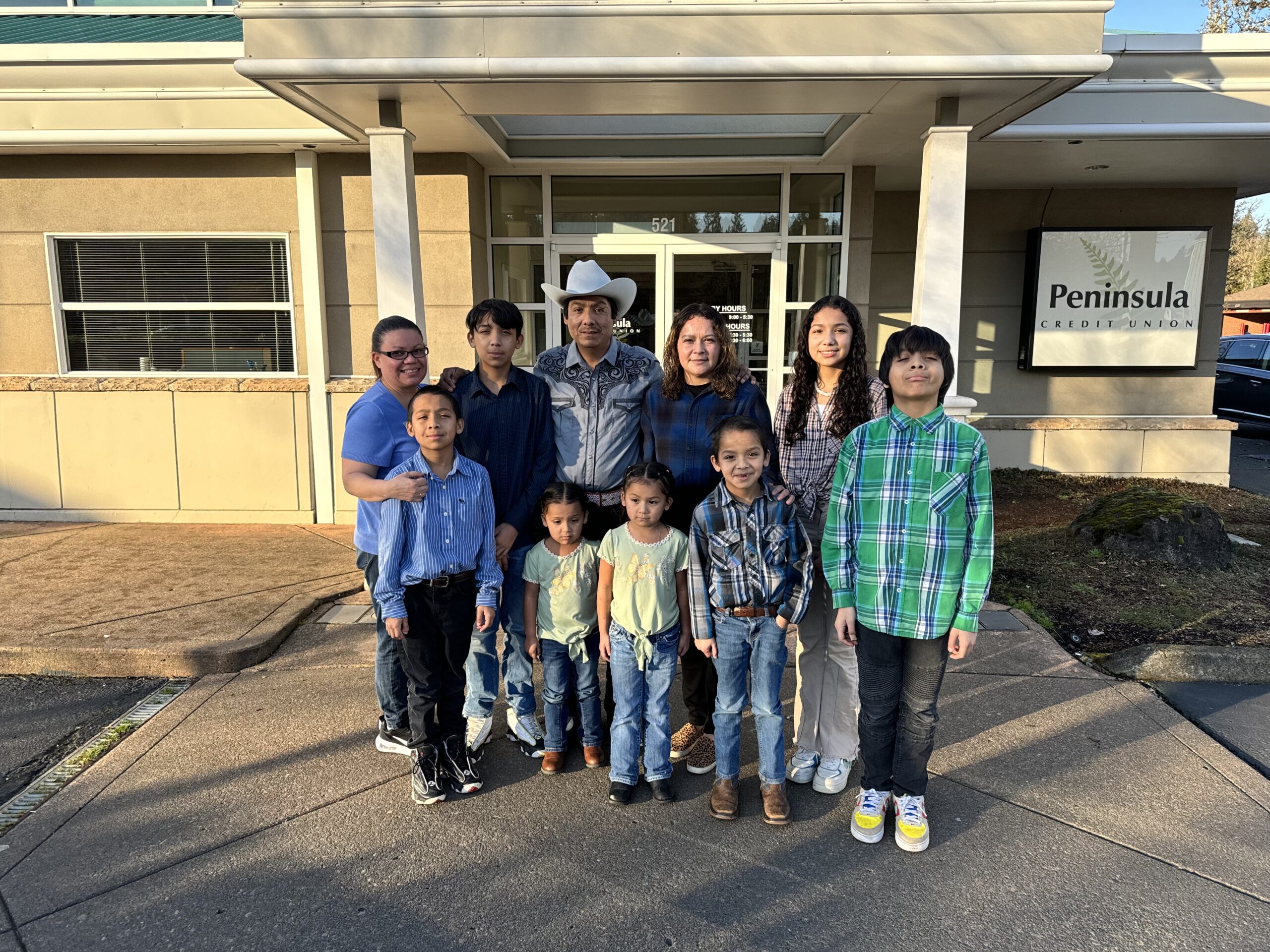 A family poses in front of the credit union