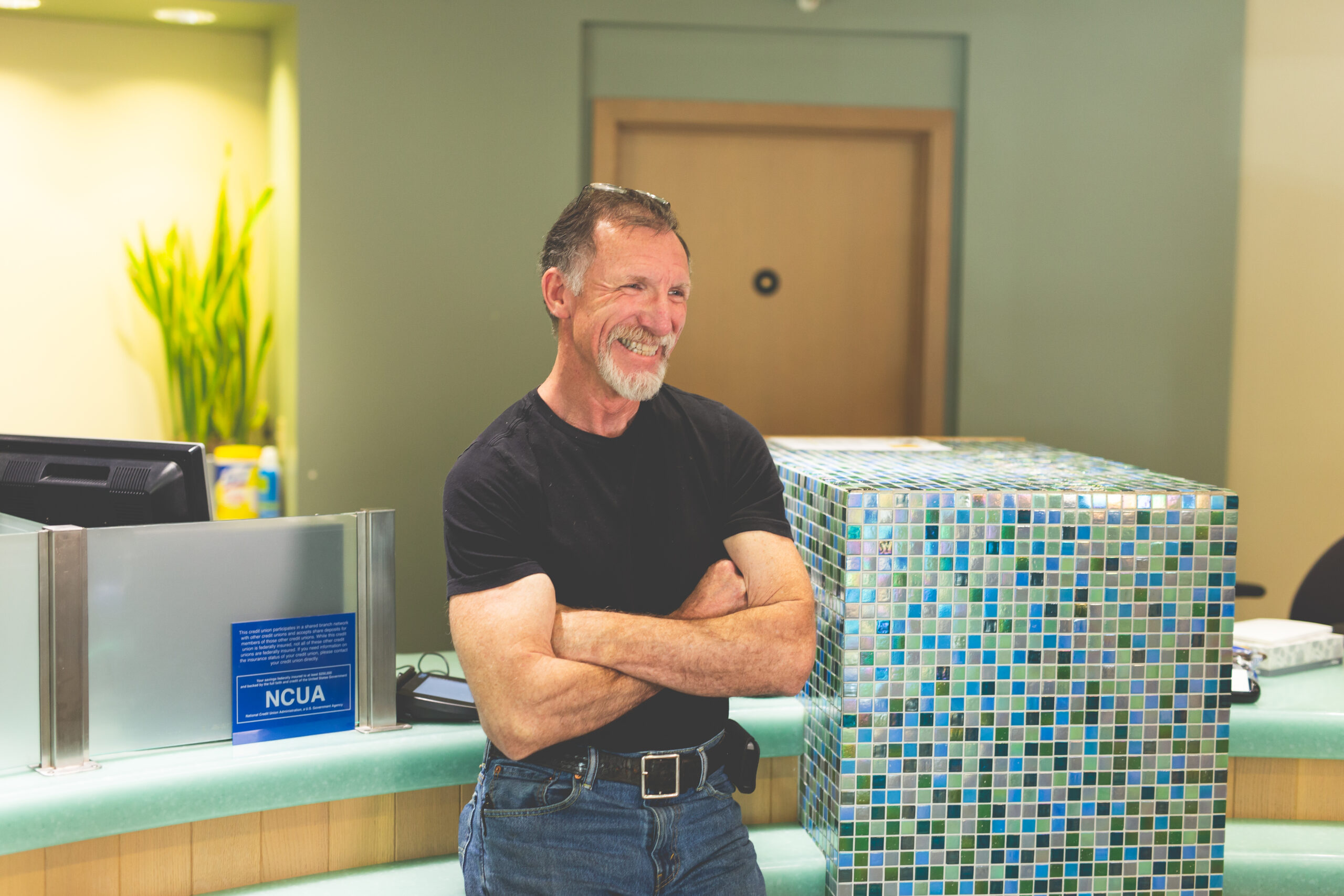A man stands in the Poulsbo branch with a smile