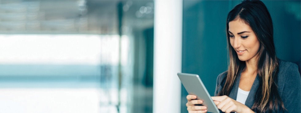 A career woman smiling and looking at an iPad