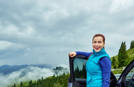 Woman standing outside car smiling