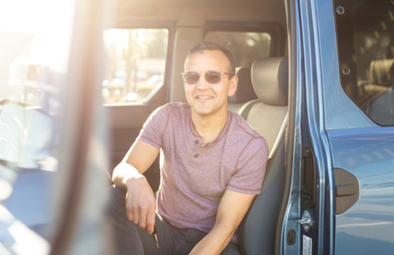 Smiling man in the front seat of a car