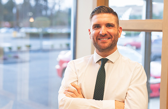 Smiling man in necktie in front of a window