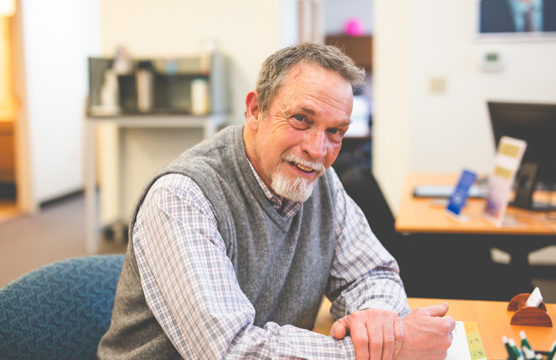 Smiling older man sitting at a desk