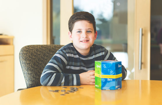 Smiling boy with change on the desk in front of him