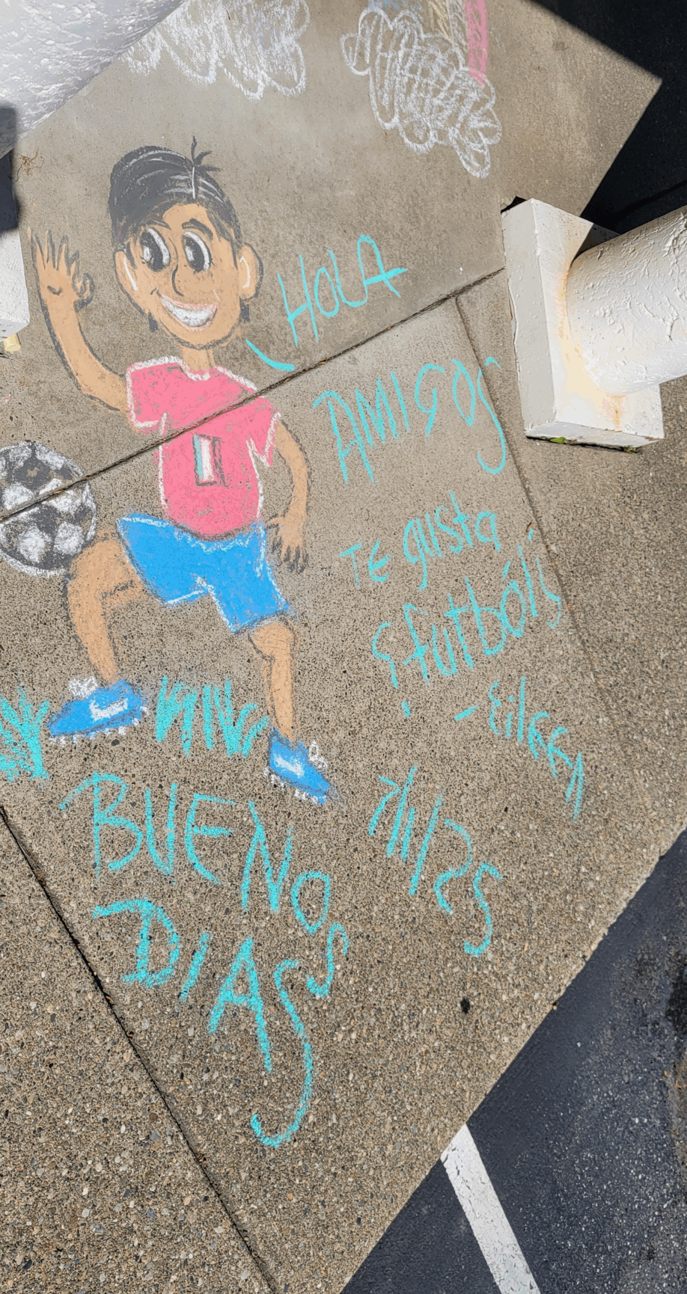 A sidewalk chalk drawing of a child playing soccer