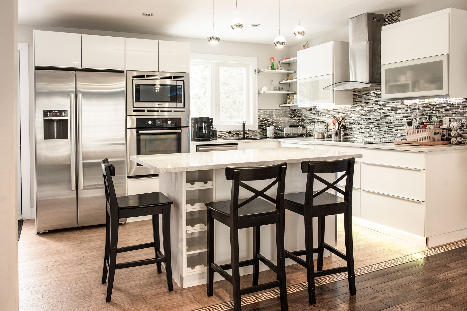 A newly remodeled kitchen with a large island with chairs around it