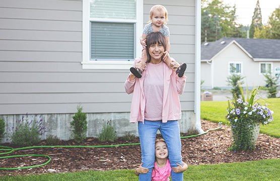 mom with two children in front yard