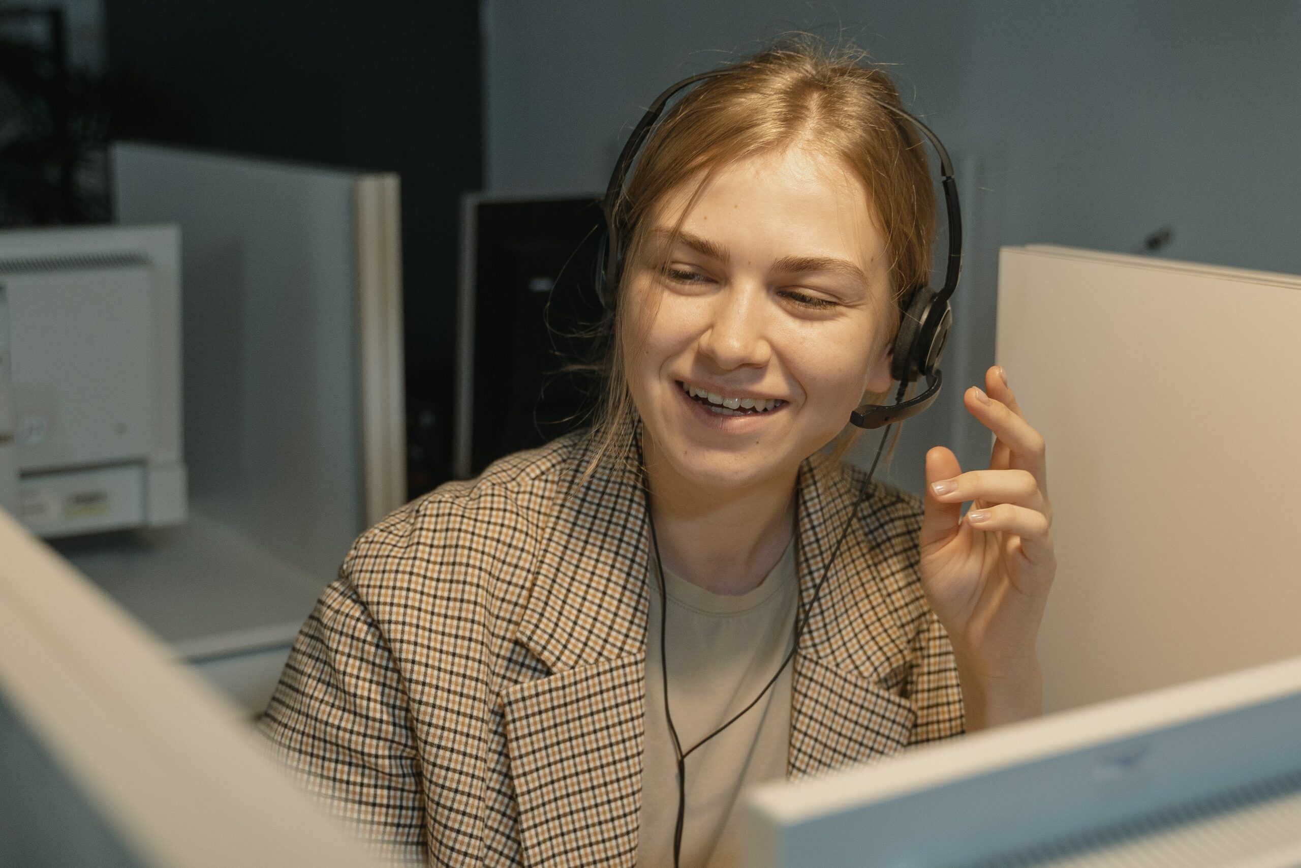 A Woman in Brown and White Plaid Blazer Wearing Black Headphones