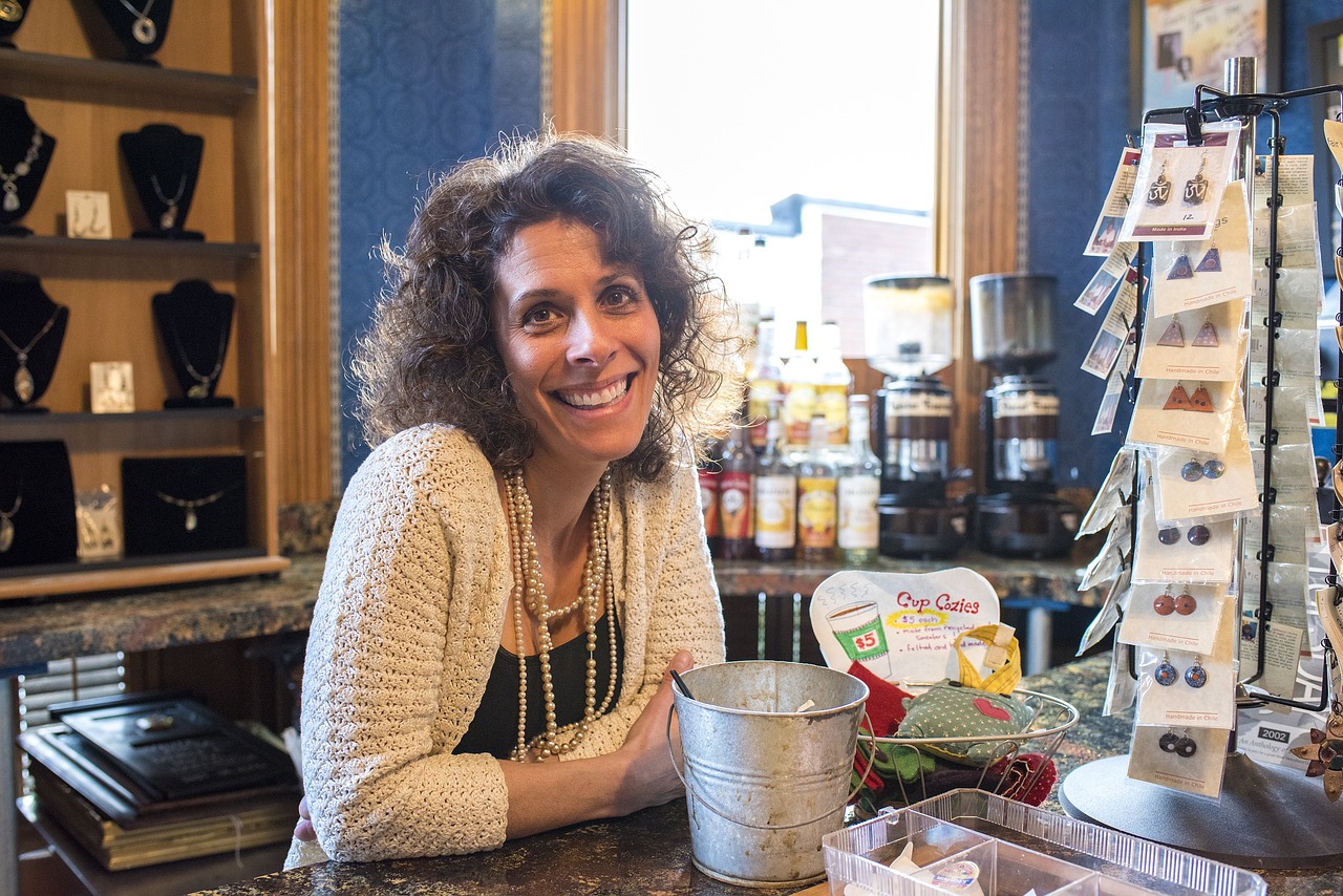 A woman smiling from behind a shop counter