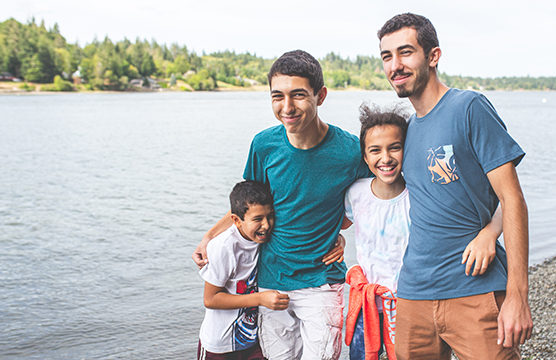 happy family embracing by the water front